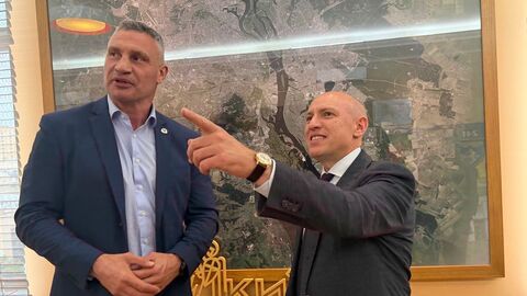 Pentz steht neben Klitschko und zeigt in die Ferne. Beide sehen fröhlich aus.